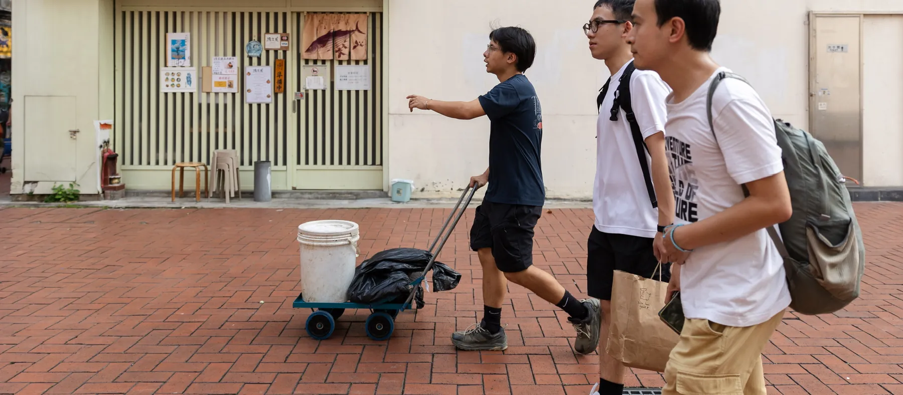 研究員推住手推車喺屯門街頭收廚餘